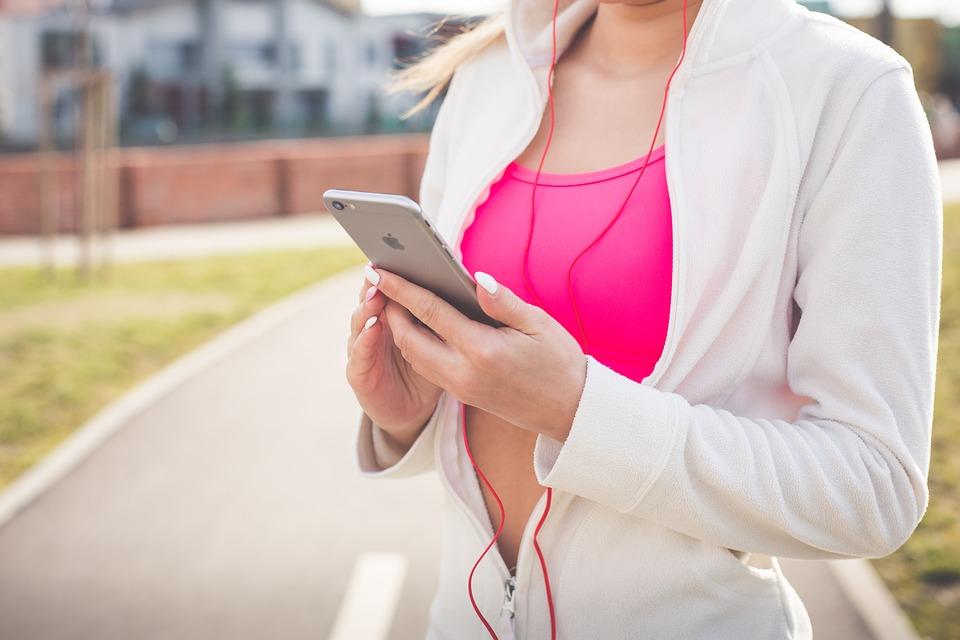 photo of a woman wearing activewear holding her cellphone