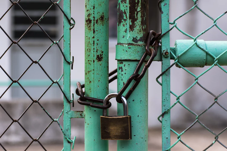 Fence held closed with a lock and chain, this place is secure and part of being secure is having a disposable number