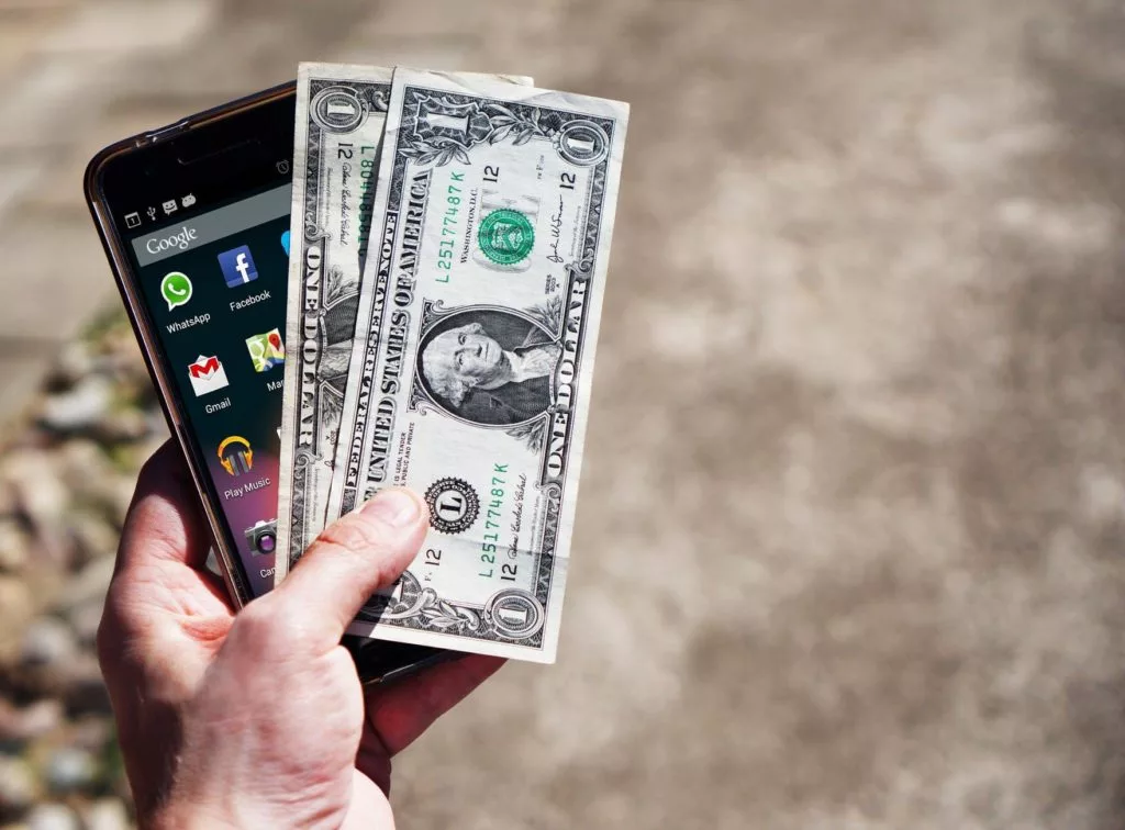 Iphone and cash in hand, ready for a deal to be made