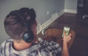 Guy looking at his phone inside house