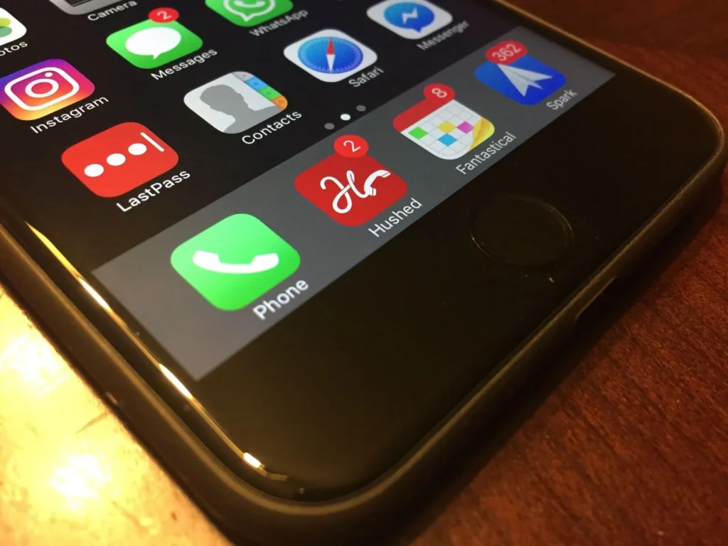 Iphone sitting on a table with the hushed app icon visible